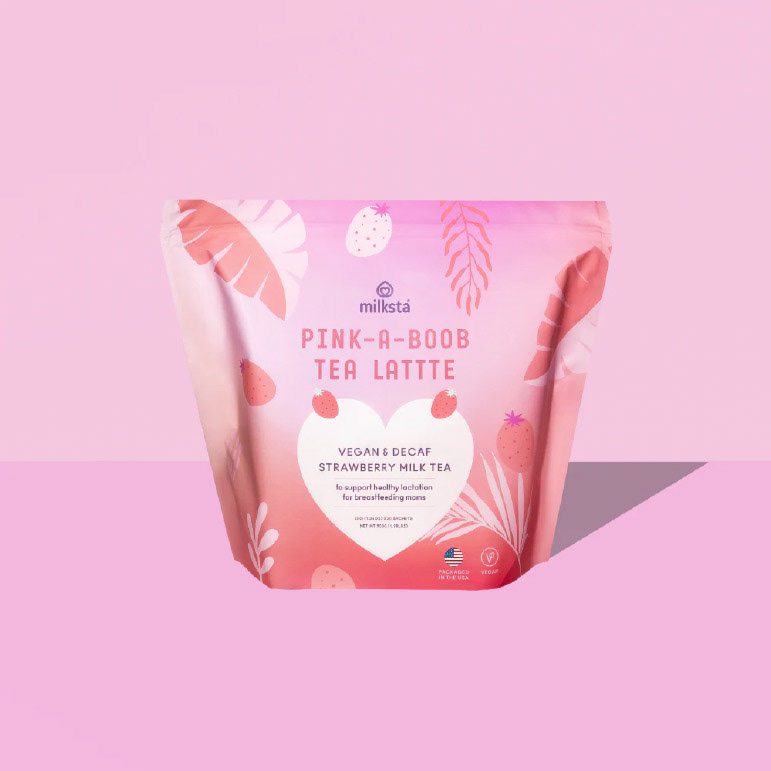 Pink Milksta strawberry tea pouch standing on a flat pink ground